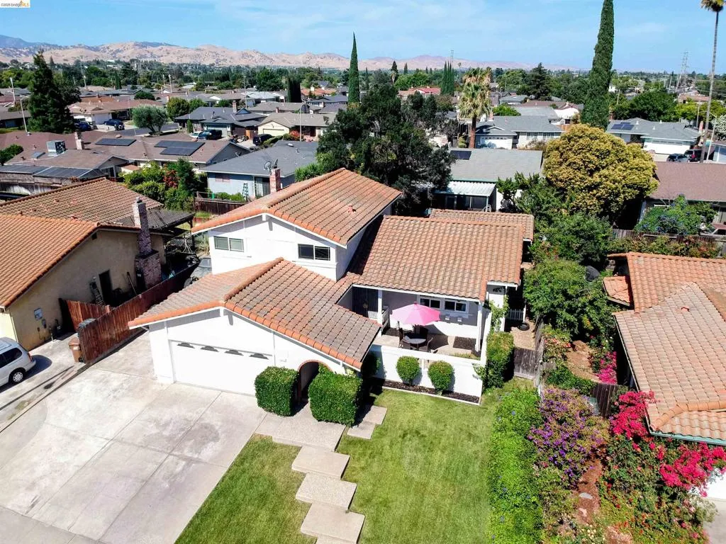 Contemporary residence featuring a two-car garage, concrete driveway, and a front lawn with stepping stones
