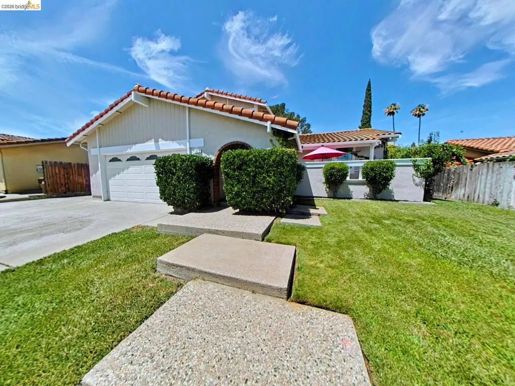 Spanish tile roof with stucco exterior, attached two-car garage, and a concrete driveway