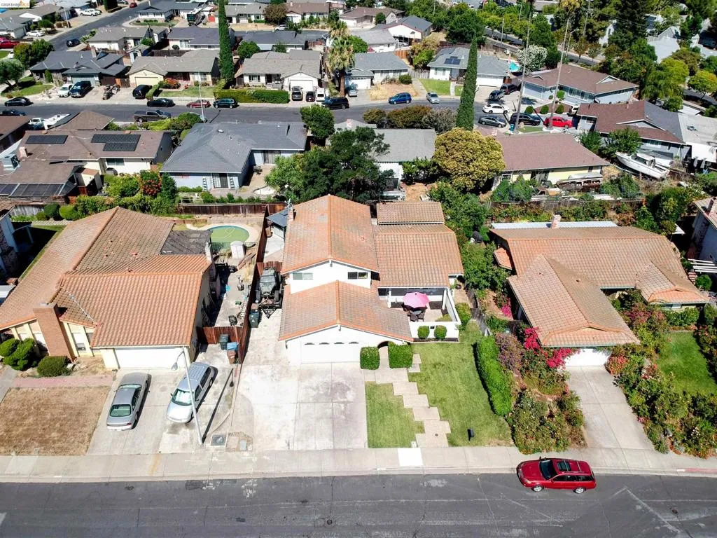 Aerial view of a residential property featuring a tiled roof and an in-ground swimming pool