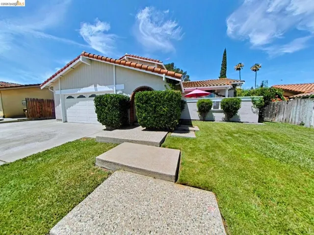 Spanish tile roof with stucco exterior, attached two-car garage, and a concrete driveway