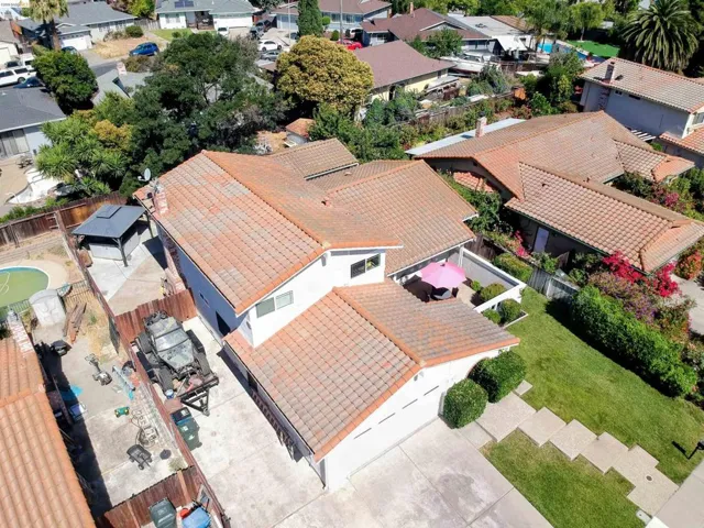 Two-story residence featuring a tile roof, an attached two-car garage, and a concrete driveway
