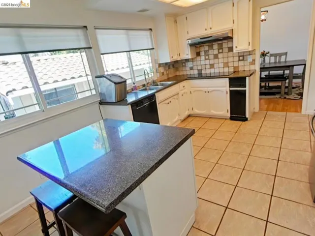 Kitchen featuring white cabinetry, dark countertops, and a tiled backsplash