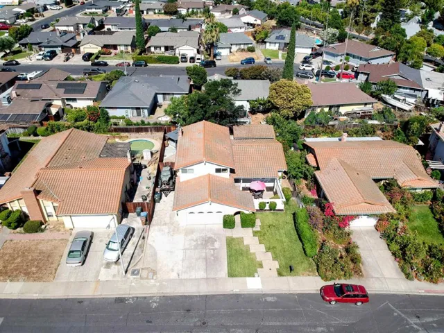 Aerial view of a residential property featuring a tiled roof and an in-ground swimming pool