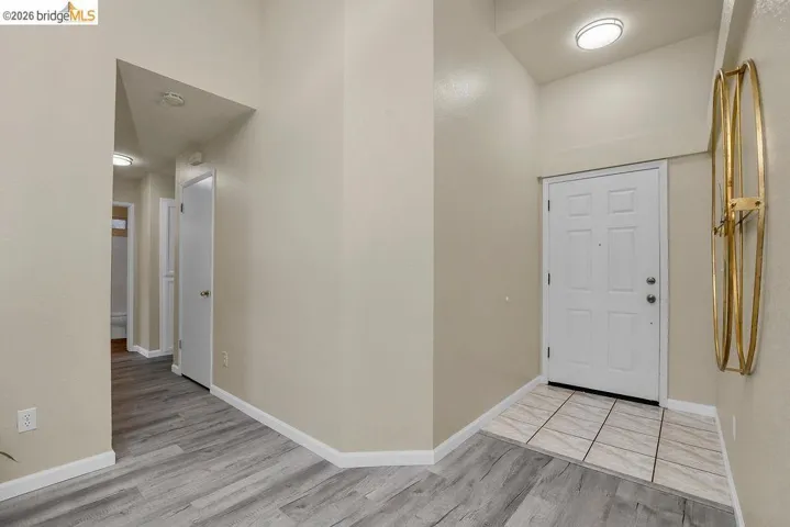 Entryway featuring a paneled door, high ceilings, and recessed lighting