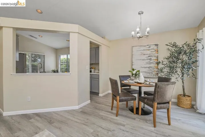 Dining area featuring wood-finish flooring and a contemporary chandelier