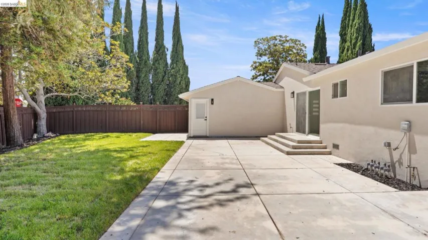 Expansive concrete patio area with multi-level steps and sliding glass doors