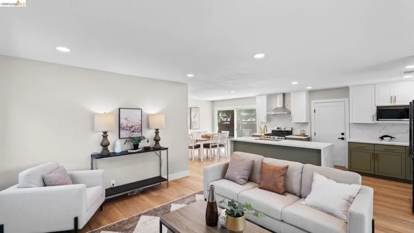 Open concept living area featuring wood-finish flooring, recessed lighting, and a neutral color palette