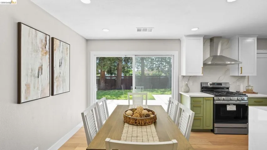 Open-concept dining area featuring light wood-finish flooring and recessed lighting