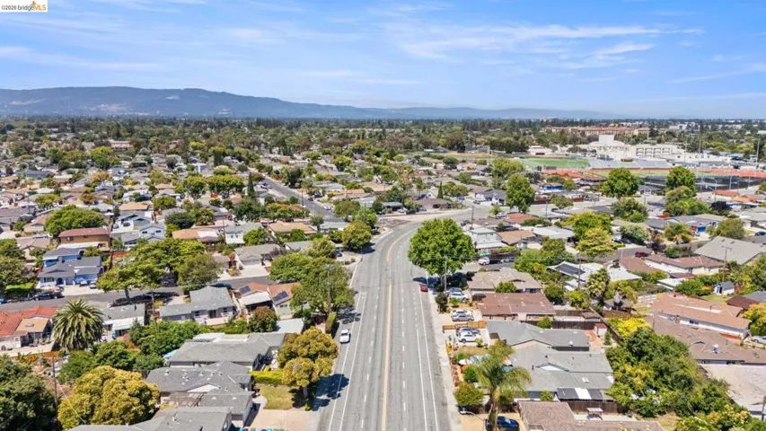 Expansive aerial perspective showcasing a residential neighborhood with tree-lined streets and varied single-story homes