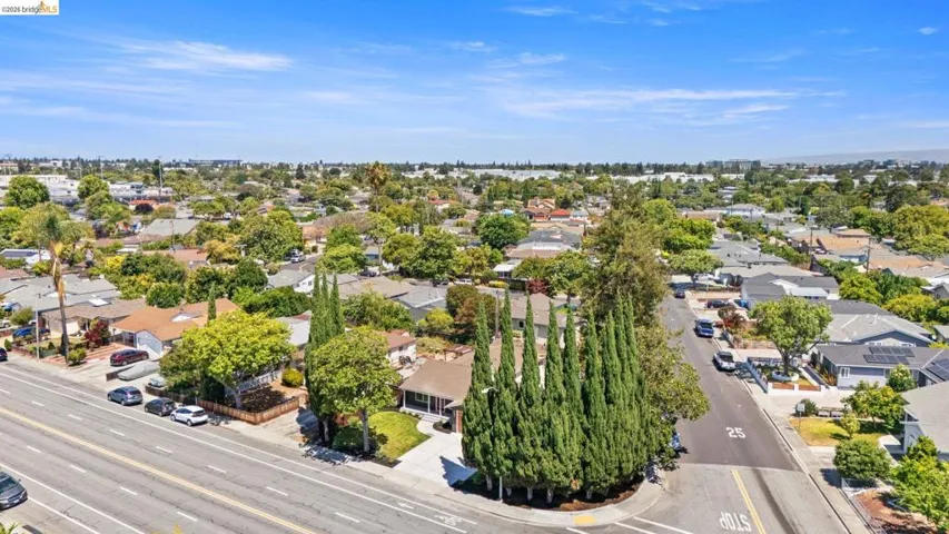 Aerial perspective highlighting the surrounding neighborhood with mature trees and residential properties