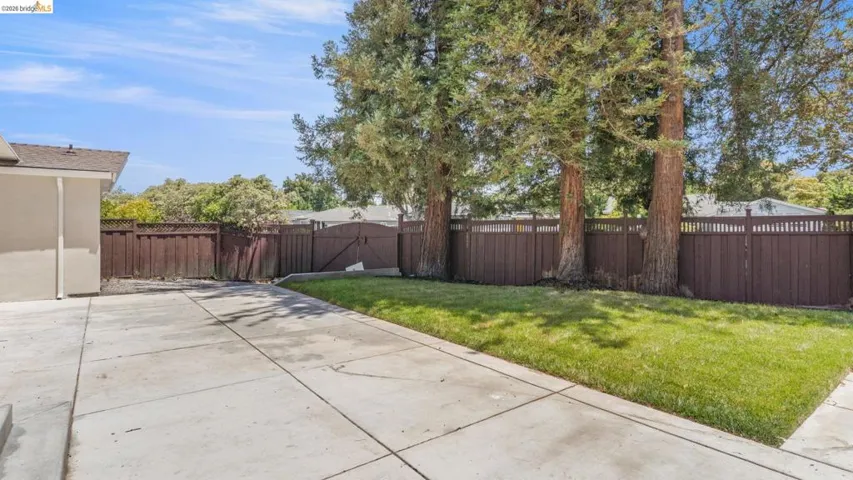 Spacious concrete patio area with a manicured lawn