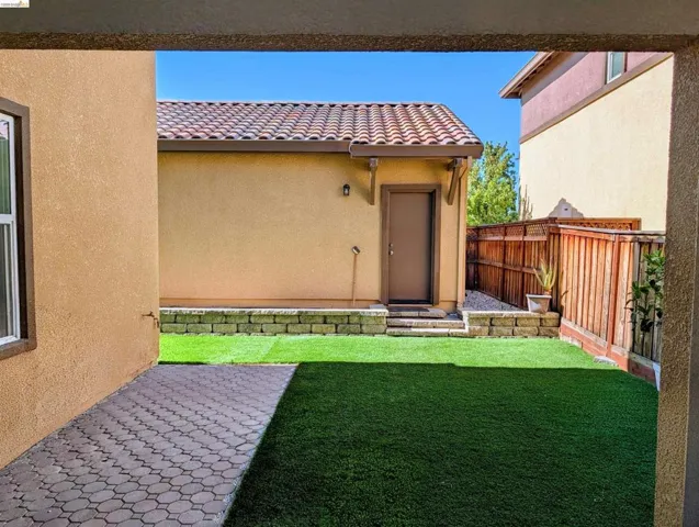 Backyard featuring artificial turf and paver patio