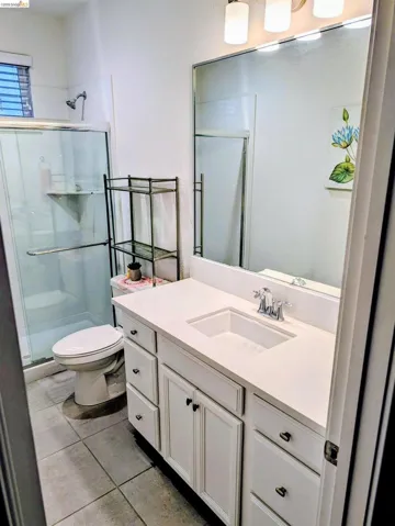 Bathroom featuring a white vanity with an integrated sink, chrome faucet, and a large wall-mounted mirror