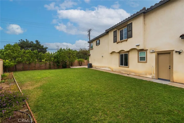 Spacious grassy backyard. Sprinklers on timer.