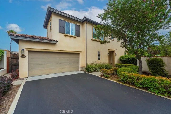 Front exterior of the home with an attached 2-car garage. Additional parking space on driveway.