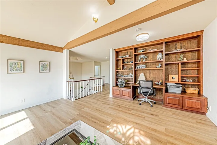 Spacious bonus room with custom built-in shelving, offering flexibility as a potential 5th bedroom
