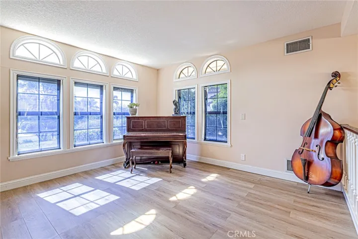 Elegant living room featuring multiple windows that showcase beautiful front yard views
