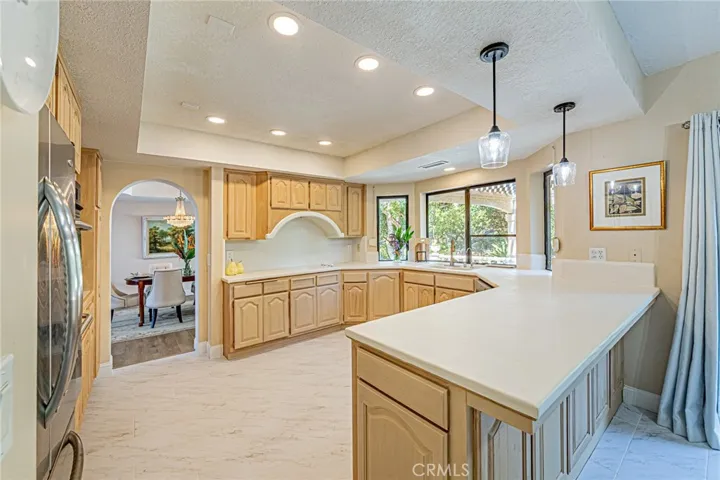 Kitchen with ceiling lighting and a cozy breakfast nook highlighted by custom designer light fixtures.