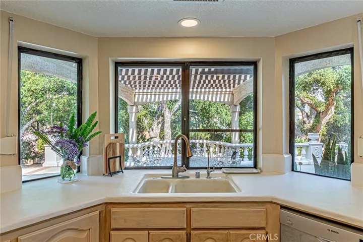 Kitchen windows overlook the backyard, offering pleasant views and abundant natural light