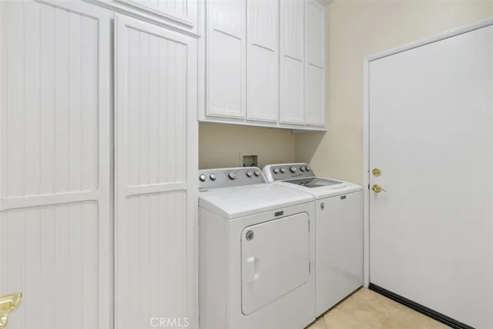Inside laundry with custom storage and broom closet.
