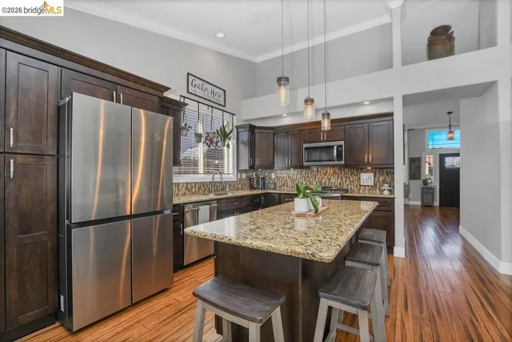 Kitchen featuring wood-finish flooring and a central island with a granite-style countertop