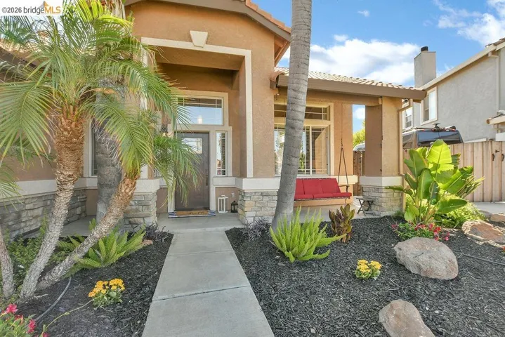 Stucco exterior with stone veneer accents and a tile roof