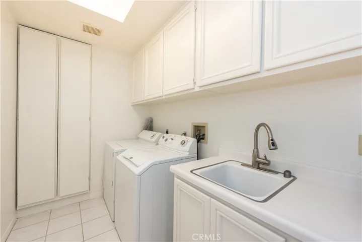 individual laundry room- wash sink, linen closets, storage cabinet