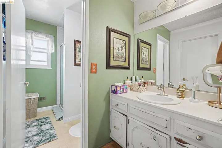 Bathroom vanity featuring an integrated sink, broad countertop, and a large wall-mounted mirror