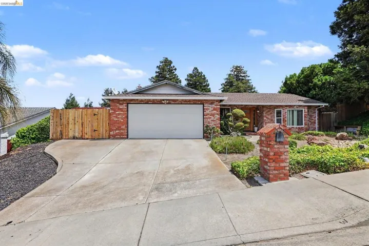 Brick exterior with an attached garage and concrete driveway