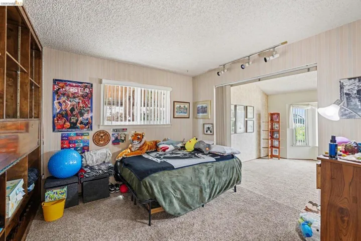 Carpeted room featuring a built-in wooden shelving unit