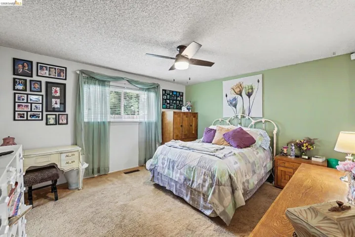 Carpeted room featuring a ceiling fan, a window with blinds, and white painted trim