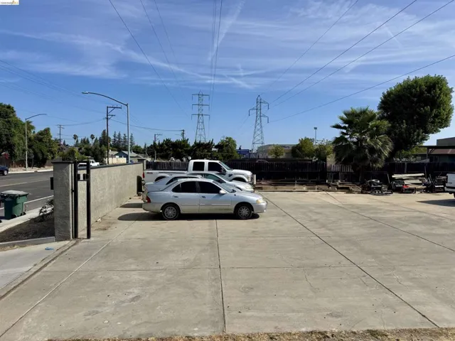 Paved concrete lot featuring a perimeter wall and a metal gate