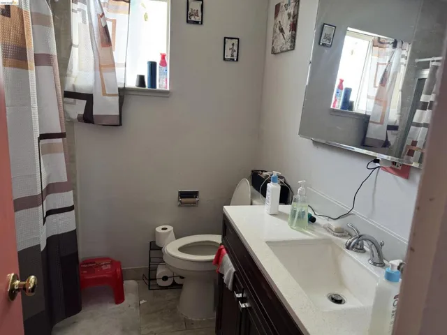Bathroom featuring a dark wood-finish vanity with a light-colored countertop, integrated sink, and chrome faucet