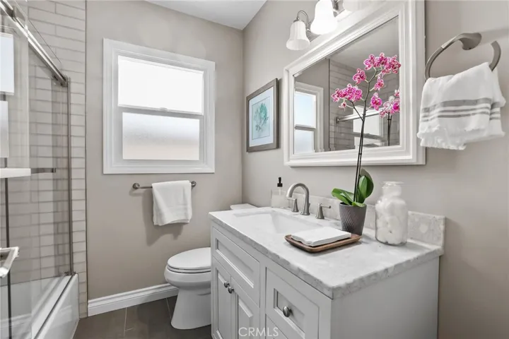 Guest bathroom is located in the hallway.  Granite counter atop a white shaker cabinet.  Porcelain subway tile accent the​​‌​​​​‌​​‌‌​​‌​​​‌‌​​​‌​​‌‌​​‌‌​​‌‌​​​​ shower/tub.