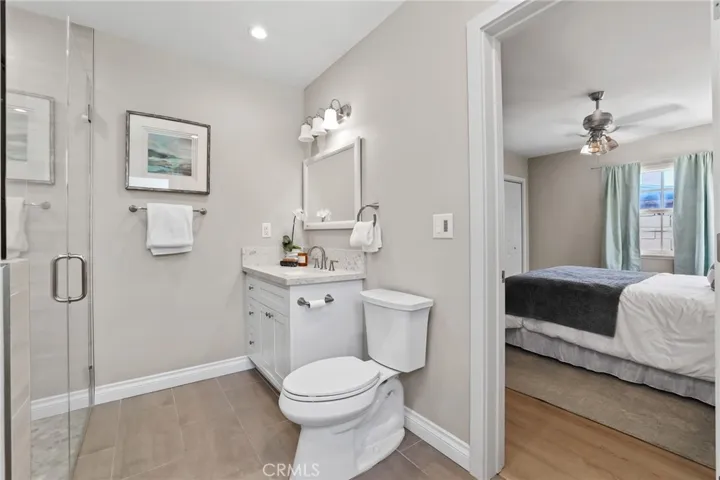 Primary en suite.  Full length glass shower with seemless transition.  Granite counters and white shaker cabinet