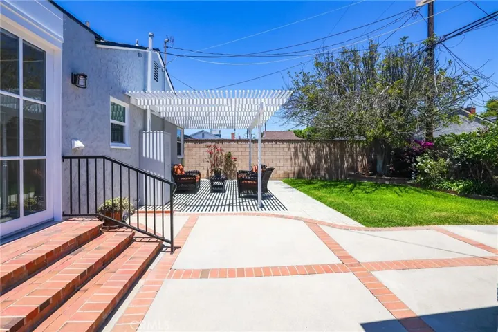 Brick ribbon accent the concrete patio and lawn.  Great place to relax under the pergola.