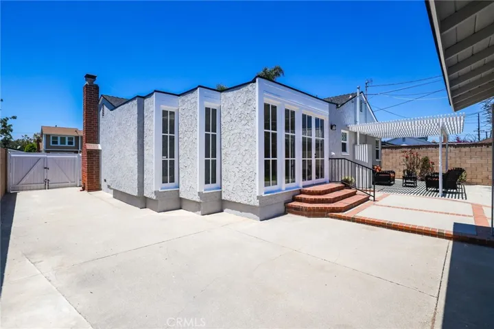 View of the double door gate access, back porch and beautiful french windows.