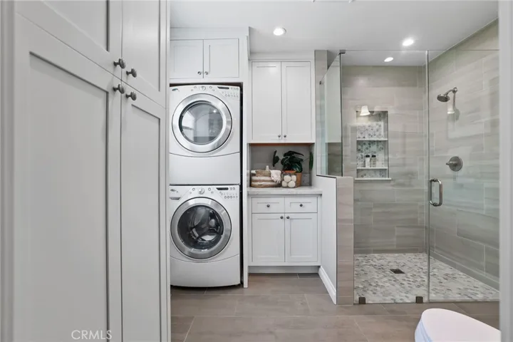 Laundry cabinet is located in the primary en suite for convenience.