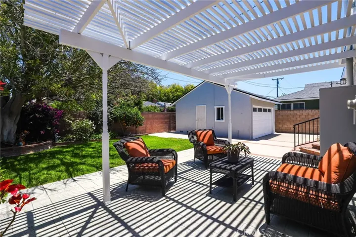 Mature tree gives shade for the grass area and planters.  Detached garage has side door access.