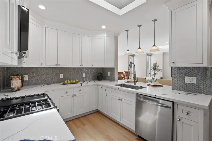 Beautiful white shaker cabinets are accented by the gas range, microwave and dishwasher.