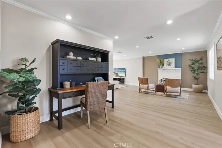 Crown molding and recessed lighting accent the spacious flooring and warm toned walls.