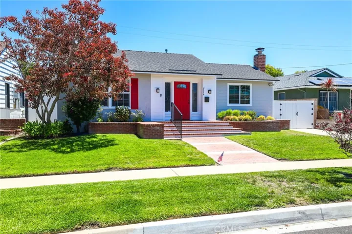 Well maintained lawn and landscape.  Pristine brick planters accent the entry door and shutters.
