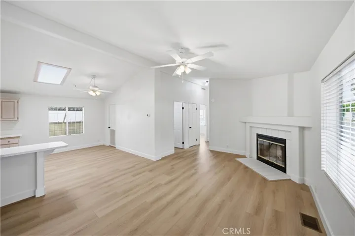 Living room with new flooring, fireplace and ceiling fan.
