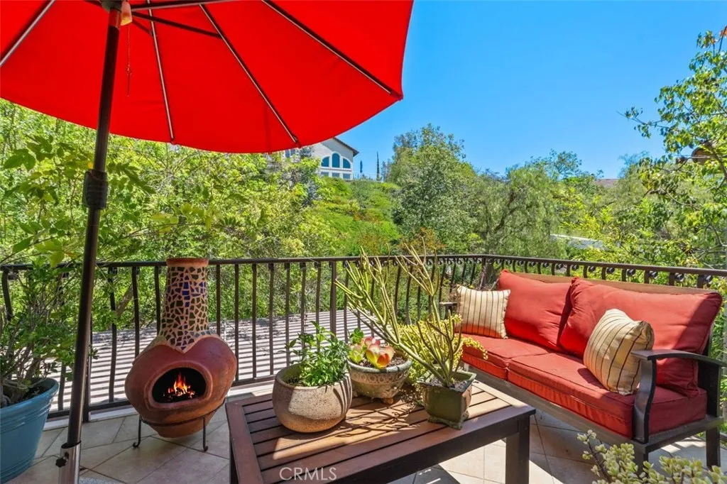 The private balcony off the primary suite offers serene treetop and hillside views, with ample space for outdoor seating. This tranquil outdoor escape perfectly complements the resort style lifestyle this home delivers.