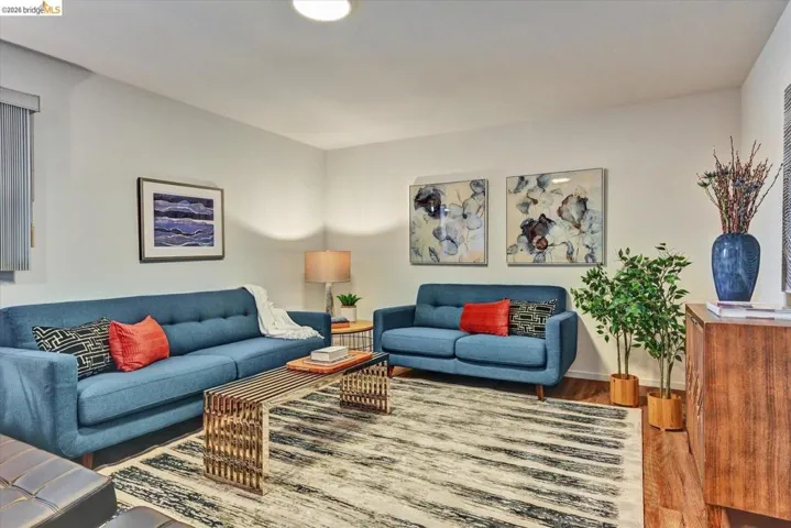 Spacious common area featuring light-toned walls, wood-finish flooring, and recessed ceiling lighting