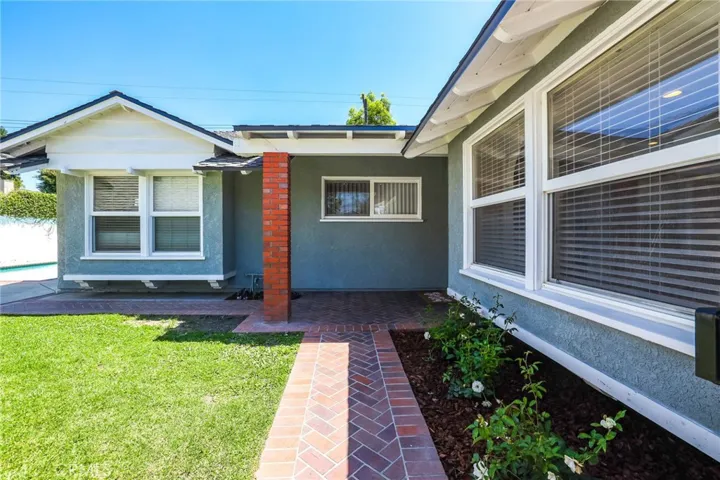 Beautiful brick ribbon walkway accents the lush green grass lawn