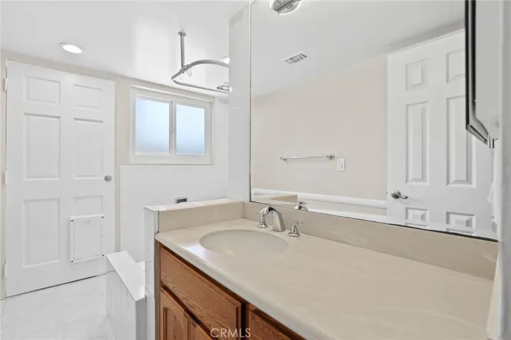 Guest bathroom has shower/tub and access door to the backyard.