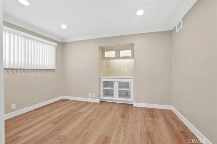 Office has built in cabinets and window that looks out to the front yard.