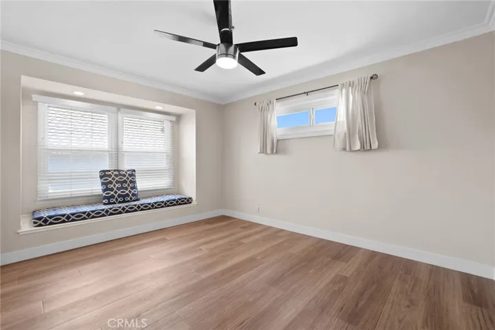 Guest bedroom #1 has large window seat and ceiling fan light.