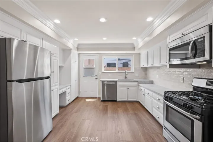 Exterior door to the side of the house. Recessed lighting and crown molding accent this space